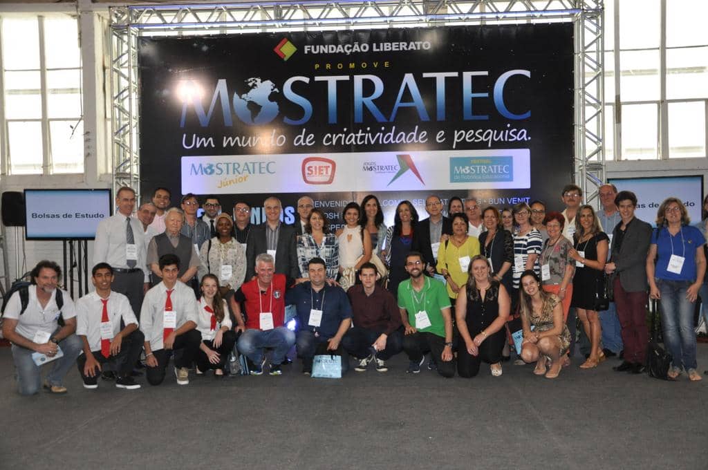Dirigentes da Fundação Liberato, alunos e Promotores em frente ao painel oficial da Mostra