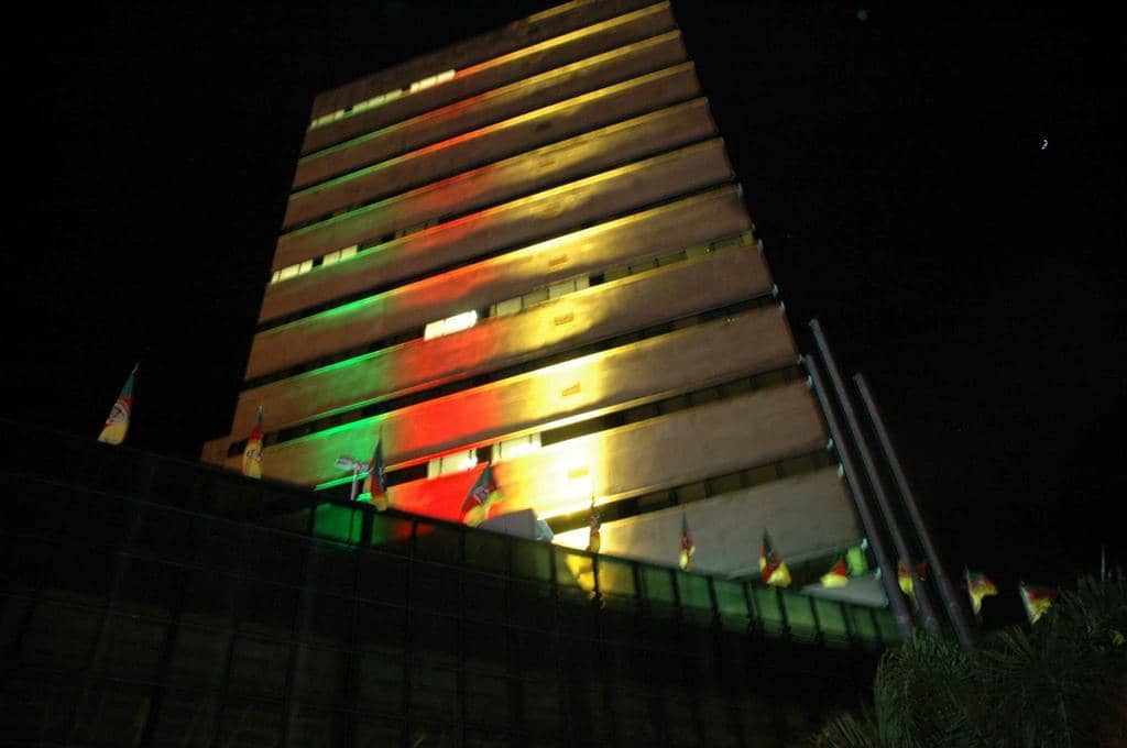 A frente do prédio iluminado com as cores da bandeira do RS